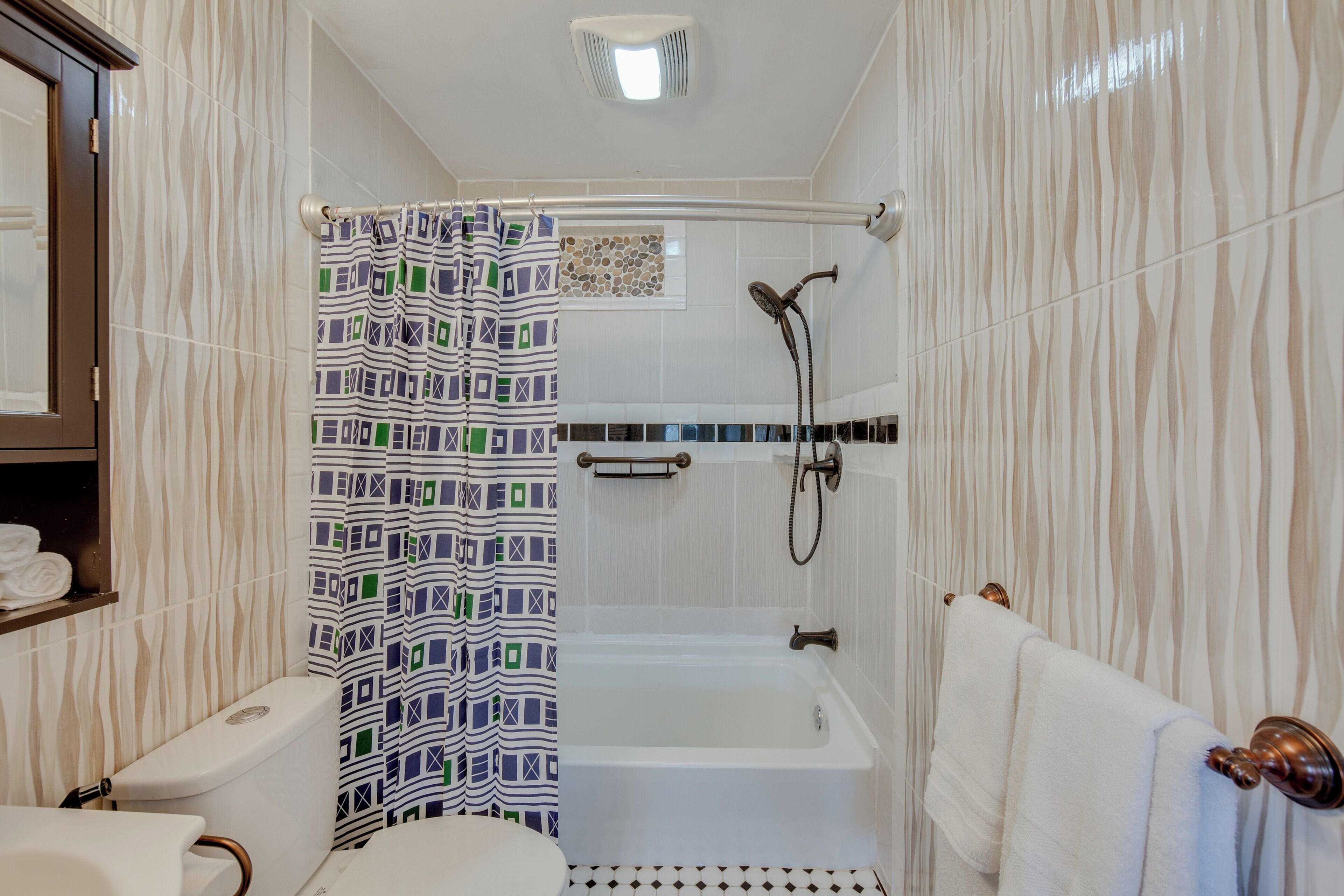 A bathroom with a shower, toilet, and bathtub.