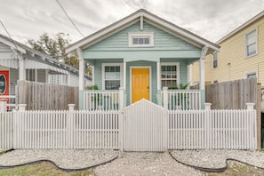 A two-story house with a yellow front door, white picket fence, and a covered porch. - Galveston Vacation Rental Near Cruise Terminals! (Galveston)