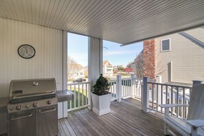 A covered outdoor area with a grill, a clock, and a potted plant. - Scituate Vacation Rental - Walk to the Beach! (Scituate)