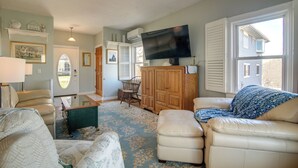 A living room with a television, leather sofas, a coffee table, and a patterned rug. - Scituate Vacation Rental - Walk to the Beach! (Scituate)