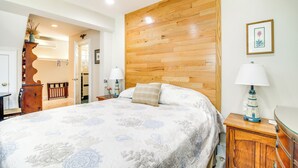 A bedroom with a large bed, wooden headboard, bedside tables, and a nightstand with a lamp. - Pet-friendly Garden Studio ~ 25 Mi to Boston! (Scituate)