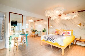 A bedroom with a bed, a desk, chairs, and a dining area. - NEWLY RENOVATED! Vibrant Exciting Nash Condo+ Pool (Nashville)