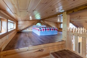 A wooden attic bedroom with a bunk bed, wooden walls, and a sloped ceiling. - Majestic Views-Hot Tub - Views - Gas Firepit -4WD-AWD (Whittier)