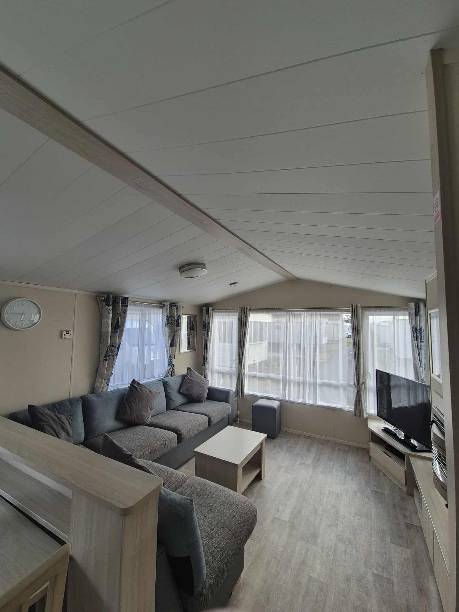 A compact living area with a sofa set, a television, and a small table.