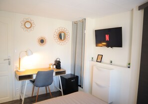 Cozy retreat with a single bed, desk, and TV, perfect for a comfortable stay.