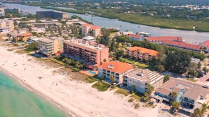 Luftaufnahme eines Küstenresorts mit Strandhäusern, einem Hafen und einem Fluss.