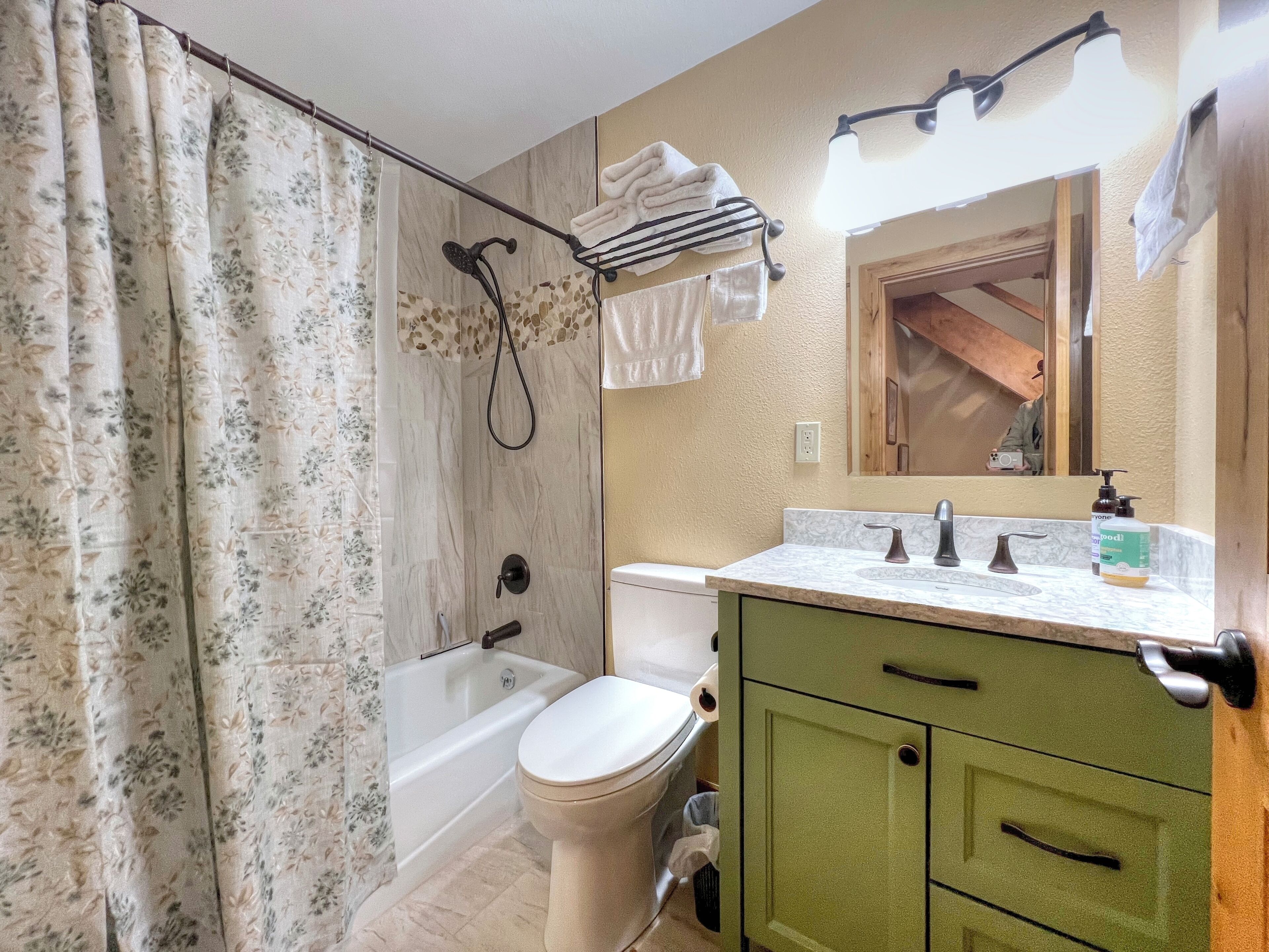 A bathroom with a shower, toilet, and sink.