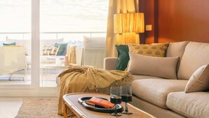 Un salon avec un canapé, une table basse sur laquelle se trouvent un plateau, des verres et une lampe.