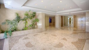A spacious lobby with a polished marble floor and a wall adorned with potted plants. - Studio with seafront terrace (Antibes)