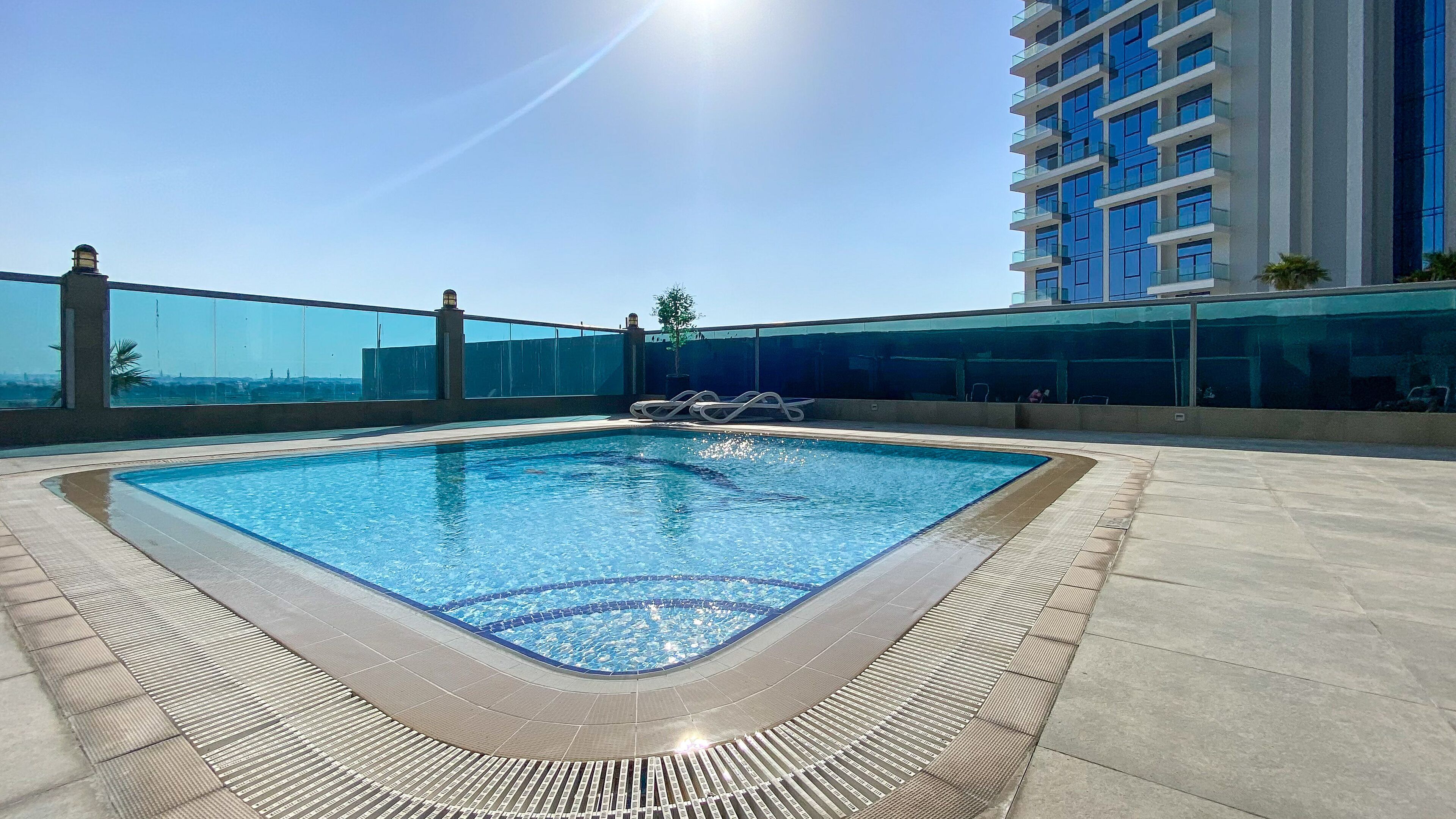 A rooftop swimming pool with a clear view of the city skyline.