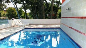 A swimming pool with a tiled wall and a clear blue water surface. - Comfort and Relax by the Pool-beahost (San Michele al Tagliamento)