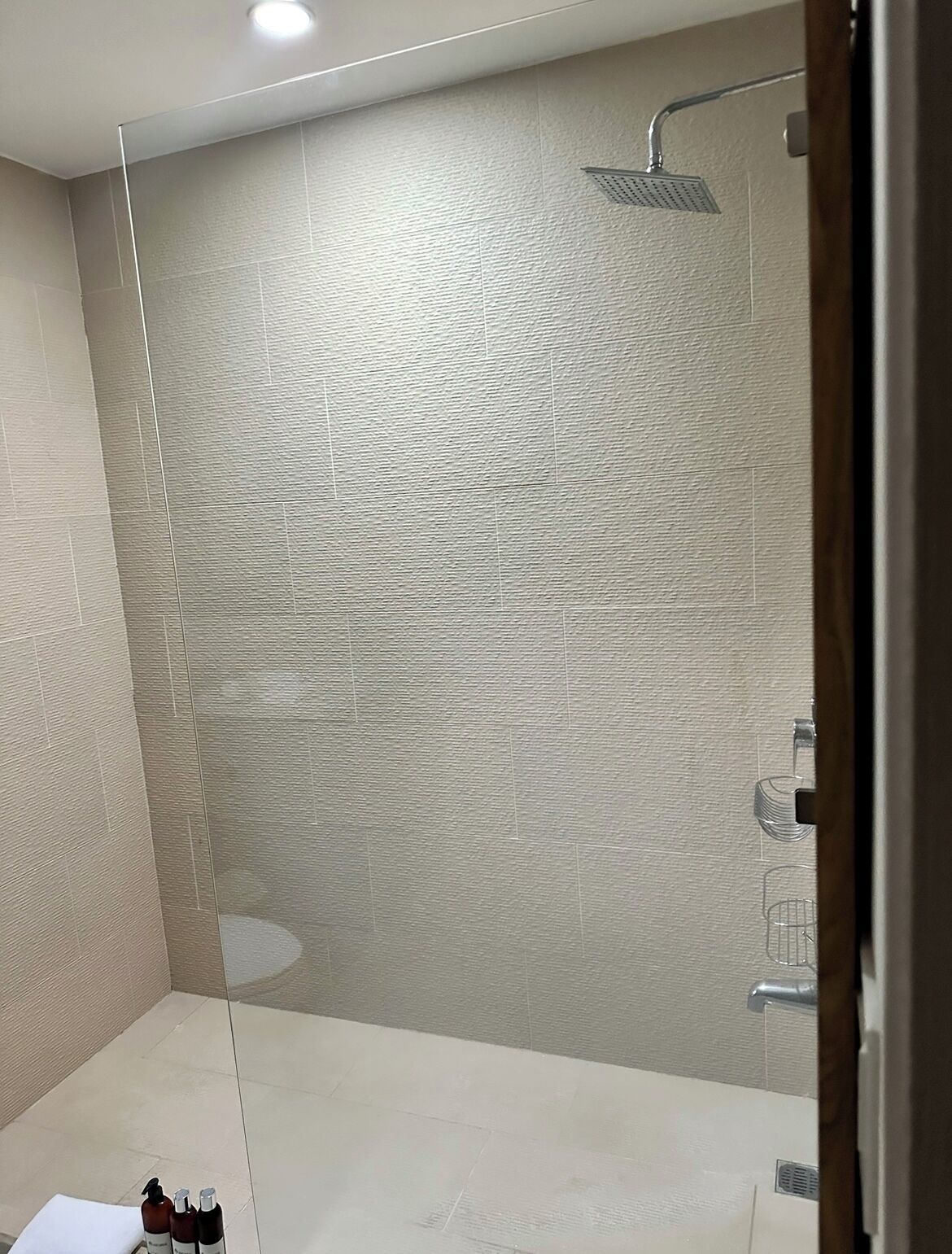 A modern bathroom with a shower, a sink, and a mirror.