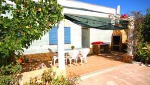 A patio area with outdoor seating, a stone wall, and a covered section. - SAONA VILLAS (VN ANGEL): villa for 4 people, private pool, wifi, near the sea (L'Ametlla de Mar)