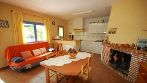 A cozy living room with a sofa, dining table, and fireplace. - SAONA VILLAS (VN ANGEL): villa for 4 people, private pool, wifi, near the sea (L'Ametlla de Mar)