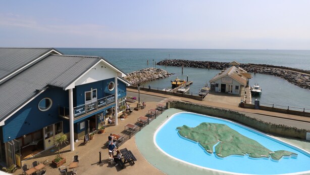 A coastal building with a pool, a bar, and a view of the sea. - Burwyns (Ventnor)