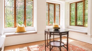 A room with large windows, a wooden table, and a bench with cushions. - Daweswood, Patterdale luxurious, spacious home with walks from the door (Patterdale)
