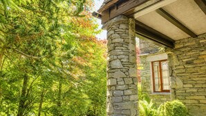 A stone building with a wooden beam ceiling, a stone pillar, and a window with a metal grill. - Daweswood, Patterdale luxurious, spacious home with walks from the door (Patterdale)
