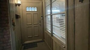 A narrow hallway with a door at the end, a window with blinds, and a number '134' on the wall. - Quick Access/ Sleeps 10/ Pets Ok (Portland)
