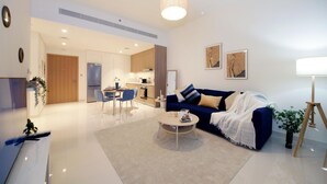 A modern living room with a sofa, coffee table, and dining area. - Luxury StayCation - Beachfront Apartment With Fantastic Palm Views  (Dubai)