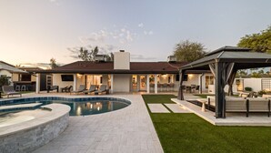 A modern house with a swimming pool, a covered patio, and a well-maintained lawn. - Scottsdale Clubhouse | Pool, Spa & Golf Simulator (Scottsdale)