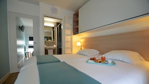 A hotel room with two beds, a bathroom, and a kitchenette. - Le Vent du Large (Saint-Gilles-Croix-de-Vie)