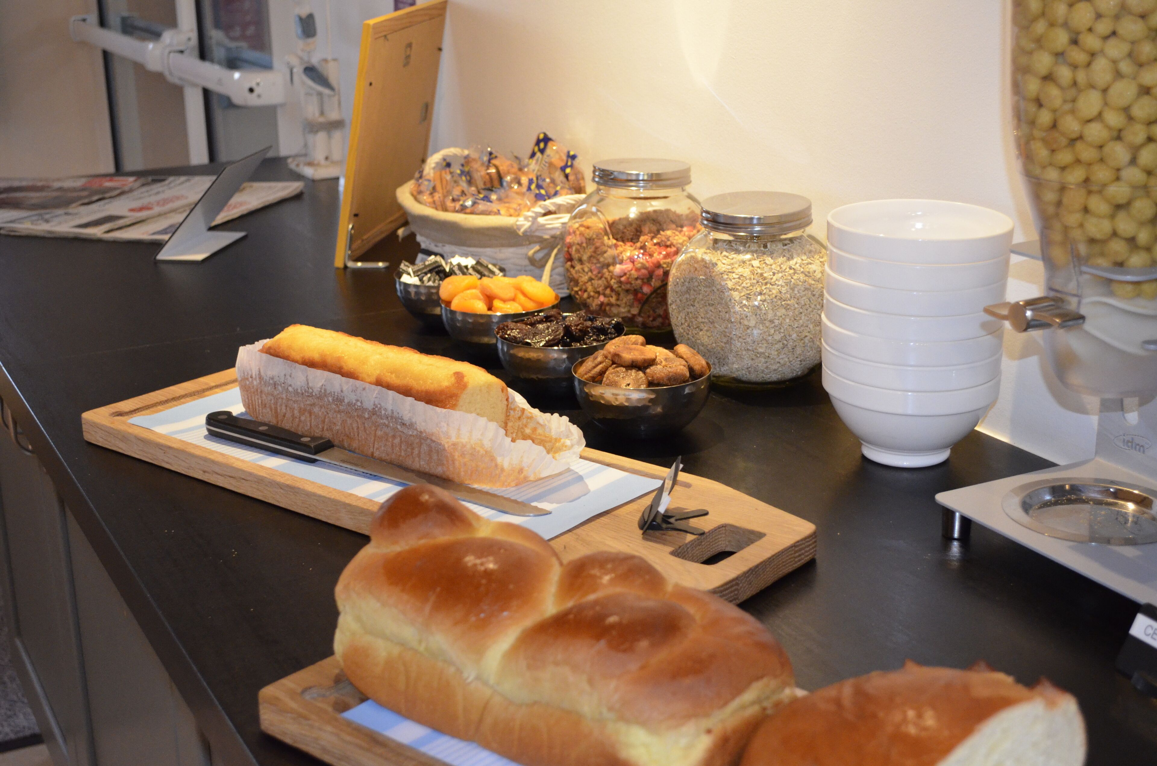 Una mesa de buffet con diversos alimentos, incluyendo pan, frutos secos y un pastel.