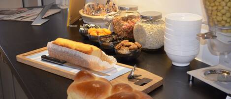 A buffet table with various food items including bread, nuts, and a cake.