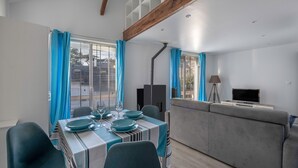 A modern living room with a dining area, grey sofa, and a TV on a stand. - Flat for 4 - 300m from the beach in La Baule (La Baule-Escoublac)
