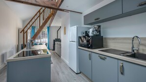 A modern kitchen with a wooden staircase, a white refrigerator, a coffee maker, and a sink. - Flat for 4 - 300m from the beach in La Baule (La Baule-Escoublac)