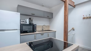 A modern kitchen with a built-in microwave, coffee maker, and electric stove. - Flat for 4 - 300m from the beach in La Baule (La Baule-Escoublac)