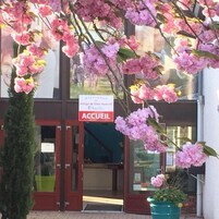 A hotel entrance with a sign reading "ACCUEL" and a welcome sign for "Village de Gites Huil".