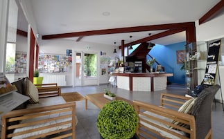 Uma área de recepção com mobiliário de madeira, um balcão e uma parede azul.