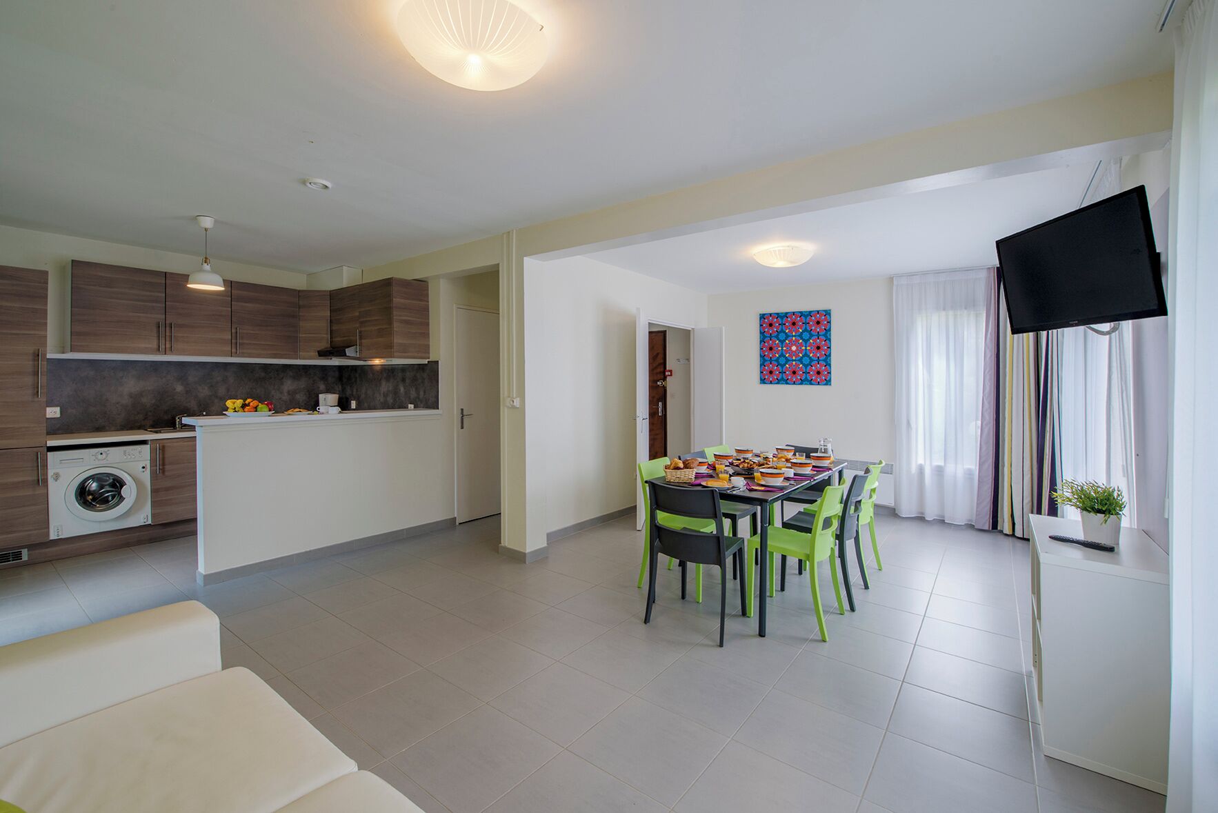 A modern apartment with a kitchen, dining area, and living space.