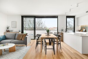 Eine moderne Küche mit Essbereich, großen Fenstern und Blick ins Freie.