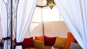 A cozy corner with a patterned sofa, a tray with glasses, and a decorative lantern. - 3 Transfert Gratuit Vers le Riad , à Votre Arrivée (Marrakech)