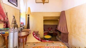 A cozy interior with a seating area, a lamp, and a decorative lantern. - 3 Transfert Gratuit Vers le Riad , à Votre Arrivée (Marrakech)