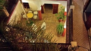 A courtyard with a seating area, potted plants, and a staircase. - 3 Transfert Gratuit Vers le Riad , à Votre Arrivée (Marrakech)