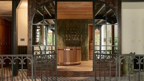 A lobby with a checkered floor, a central wooden reception desk, and metal railings. - La Chapelle du Carmel - Centre Ville - SPA (Reims)