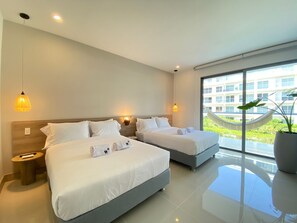 Une chambre d’hôtel moderne avec deux lits, une grande fenêtre donnant sur un espace verdoyant et un bâtiment, ainsi qu’une plante en pot.