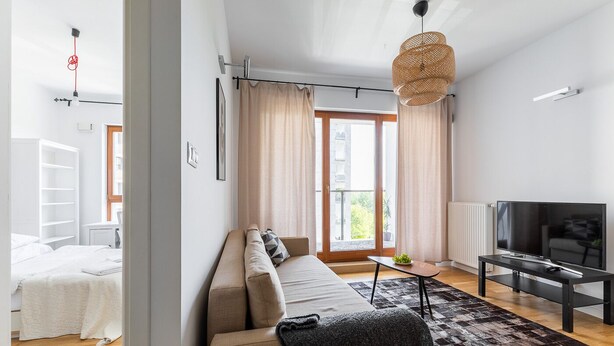 Ett modernt vardagsrum med en soffa, en tv och ett matbord.