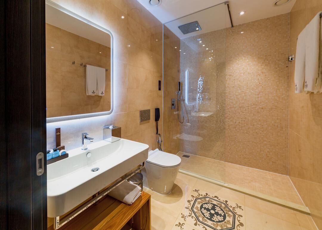 Een moderne badkamer met een douchecabine van glas, een wit wastafelmeubel en een grote spiegel.