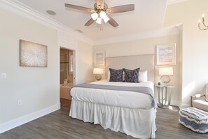 A bedroom with a large bed, a ceiling fan, and two bedside lamps. - Ocean View Home with Pool in Gated Community - 1 Min Walk to Ocean (Destin)