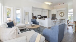 Een ruime woonkamer met een grote bank, een salontafel en een eethoek met een tafel en stoelen.