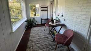 A cozy room with a wooden bench, a table with chairs, a potted plant, and a view of the outdoors. - Have a Spring Fling or Work Remote - Hi Speed  WIFI! (Chicago)