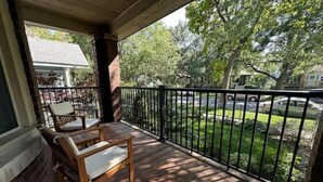 A wooden deck with a bench and a railing overlooking a street. - Have a Spring Fling or Work Remote - Hi Speed  WIFI! (Chicago)