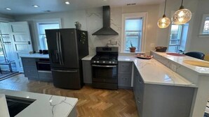 A modern kitchen with a large island, built-in appliances, and pendant lighting. - Have a Spring Fling or Work Remote - Hi Speed  WIFI! (Chicago)