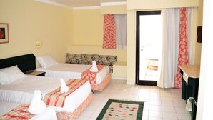 Une chambre d’hôtel avec deux lits, un bureau et une vue sur l’extérieur.