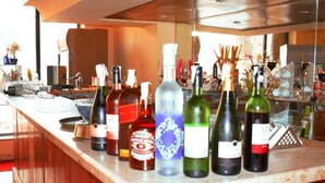 Un espace bar avec différentes bouteilles d’alcool, des verres et des ustensiles de bar.