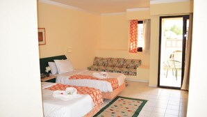 A hotel room with two beds, a sofa, a patterned curtain, and a view of the outside. - Single Room LA
الغردقه
ميدان المحمدي الهضبه اول الممشى السياحي
 (Hurghada)
