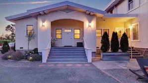 A two-story house with a front porch, steps leading to the entrance, and a landscaped front yard. - Casa Bella Estate in Wine Country w/ New Pool! (Kenwood)